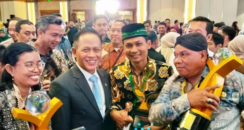 KRJogja.com-Istimewa Ketua Proklim Klewonan, Triharjo, Wates, Suyatin (berpeci) foto bersama Menteri Lingkungan Hidup Hanif Faisol Nurrofiq usai menerima penghargaan. (dua kiri).