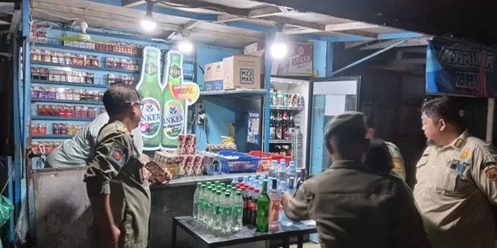 Petugas Satpol PP memeriksa berbagai merek minuman beralkohol yang dijual warung/toko. (foto:said masykuri) 