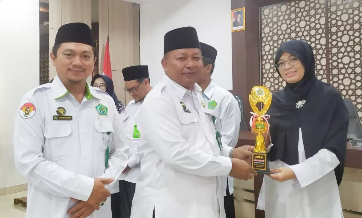 Kankemenag Kabupaten Bantul, H. Mutholib menyerahkan penghargaan kepada Kepala MA Madania Bantul, Anis Fatiha..  (Istimewa)