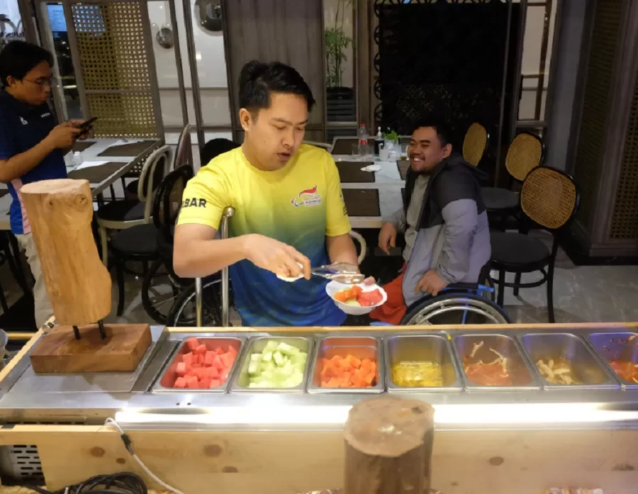 Potret atlet dari NPCI Jawa Barat mengambil potongan buah saat sarapan di Hotel Solia Zigna Kampung Batik Laweyan, Surakarta, Kamis (3/10/2024).  (Foto: PB Peparnas XVII/Kurniawan Arie Wibowo)