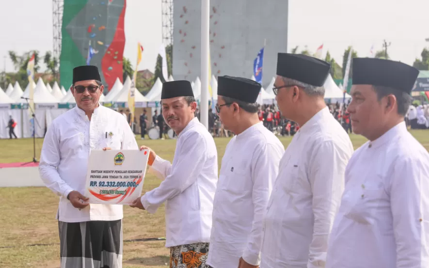 Potret Pj Gubernur Jateng Nana Sudjana menyerahkan bantuan insentif pengajar keagamaan pada peringatan Hari Santri Nasional, di Kabupetan Blora, Selasa (22/10/2024). (Foto: Humas Pemprov)