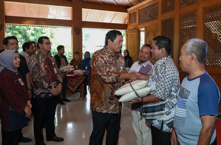 Pj Gubernur Jateng Nana Sudjana menyerahkan bantuan beras kepada KPM di Pendapa Kecamatan Pasar Kliwon, Kota Surakarta pada Selasa (5/11/2024). (Foto: Humas Pemprov Jateng)