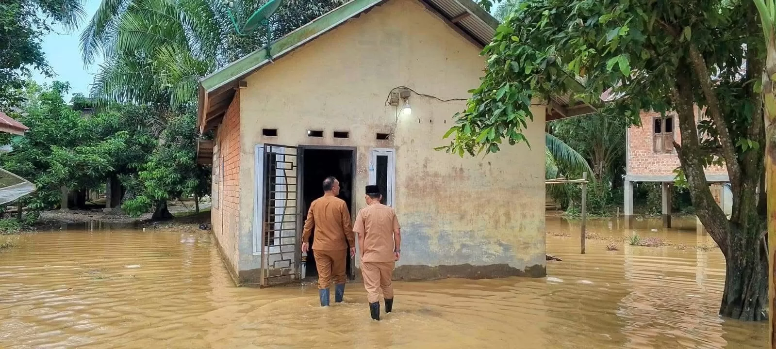 Bupati Hurmin saat meninjau salah satu rumah yang terkena banjir di kawasan Pauh. (Mario Dwi Kurnia/metrojambi.com)