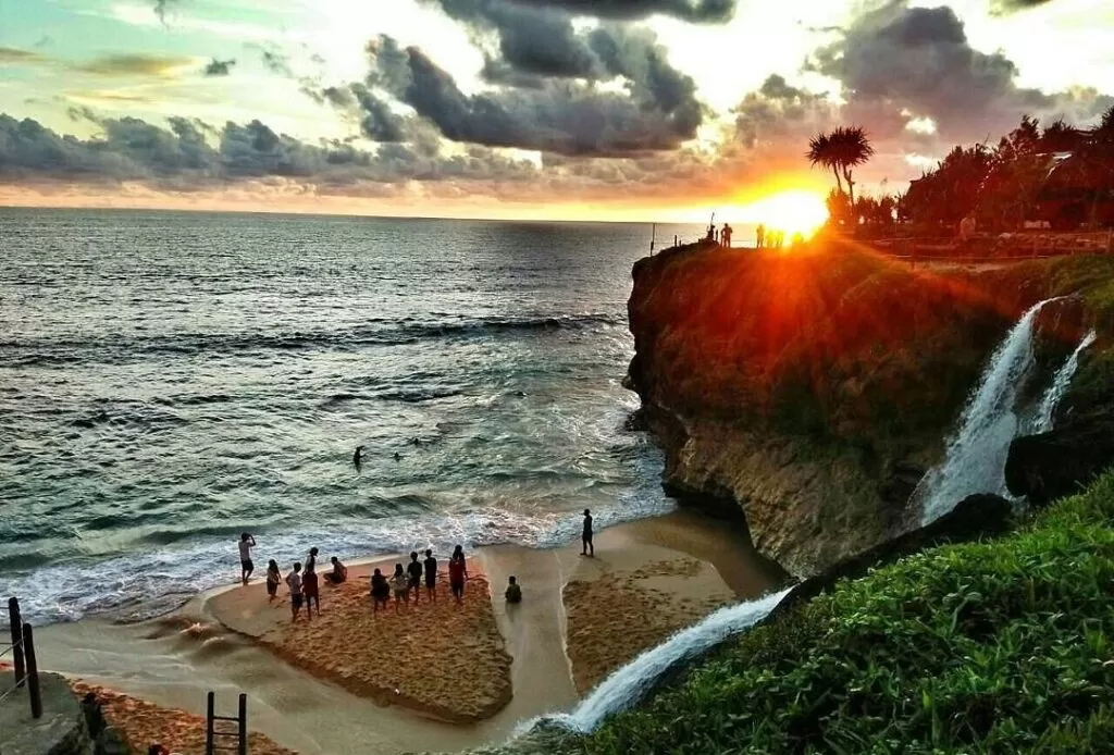 Keindahan air terjun di Pantai Banyu Tibo yang mengalir langsung ke laut biru jernih, menciptakan pemandangan yang memukau