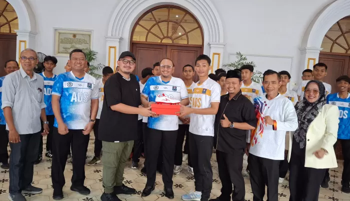 Dokter Dewa Taruna Nugraha (Baju Hitam) mewakili ayahnya Anggota Komisi X DPR RI Dr Agung Widyantoro SH M.Si menyerahkan Bantuan sepatu untuk Atlet Sepakbola Kota Tegal (Dok/Vimanews.id)