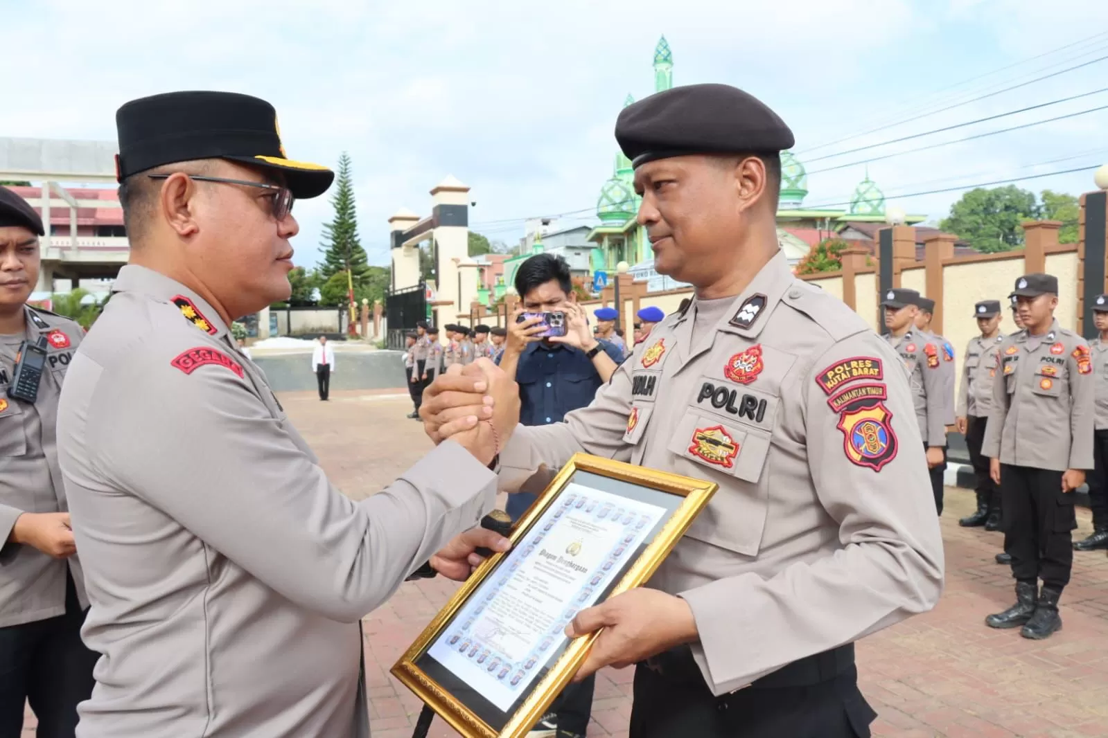 APRESIASI: Kapolres AKBP Kade Budiyarta menyerahkan piagam penghargaan kepada salah satu personel Polres Kubar berprestasi. (LUKMAN HAKIM/KP)  