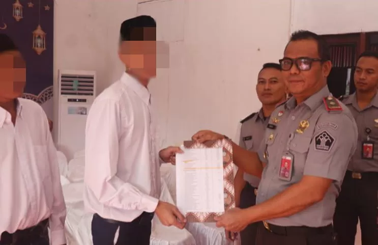 SERAHKAN SK: Kepala Rutan Kelas IIB Balikpapan Agus Salim (kanan) menyerahkan SK remisi khusus Idulfitri 1445 H kepada salah seorang WBP.&nbsp;   (RUTAN BALIKPAPAN for KP)
