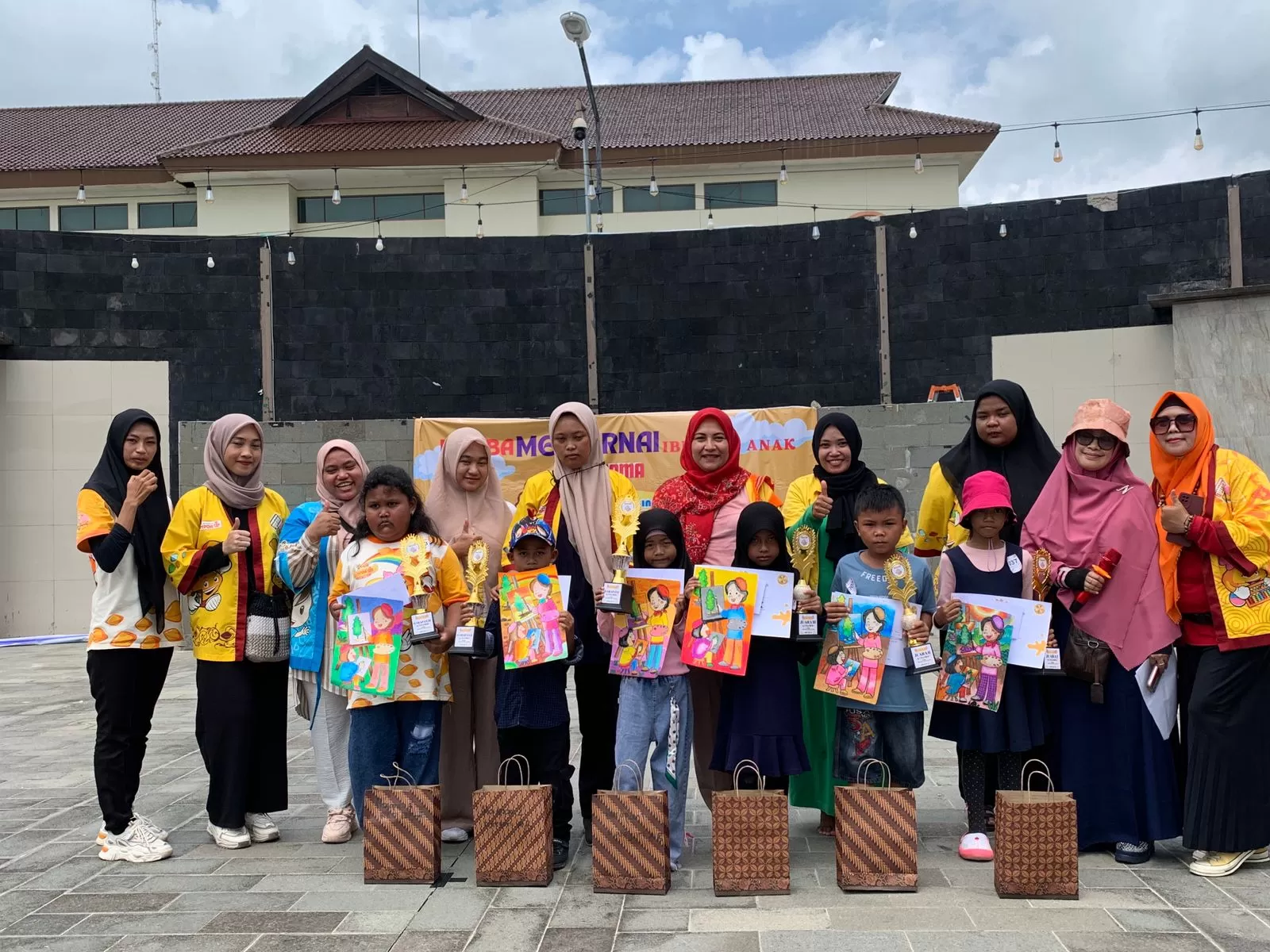 ANTUSIAS: Yusfa (jilbab merah) bersama panitia dan peserta usai lomba mewarnai di Alun-Alun Penajam, Sabtu (27/4/2024).