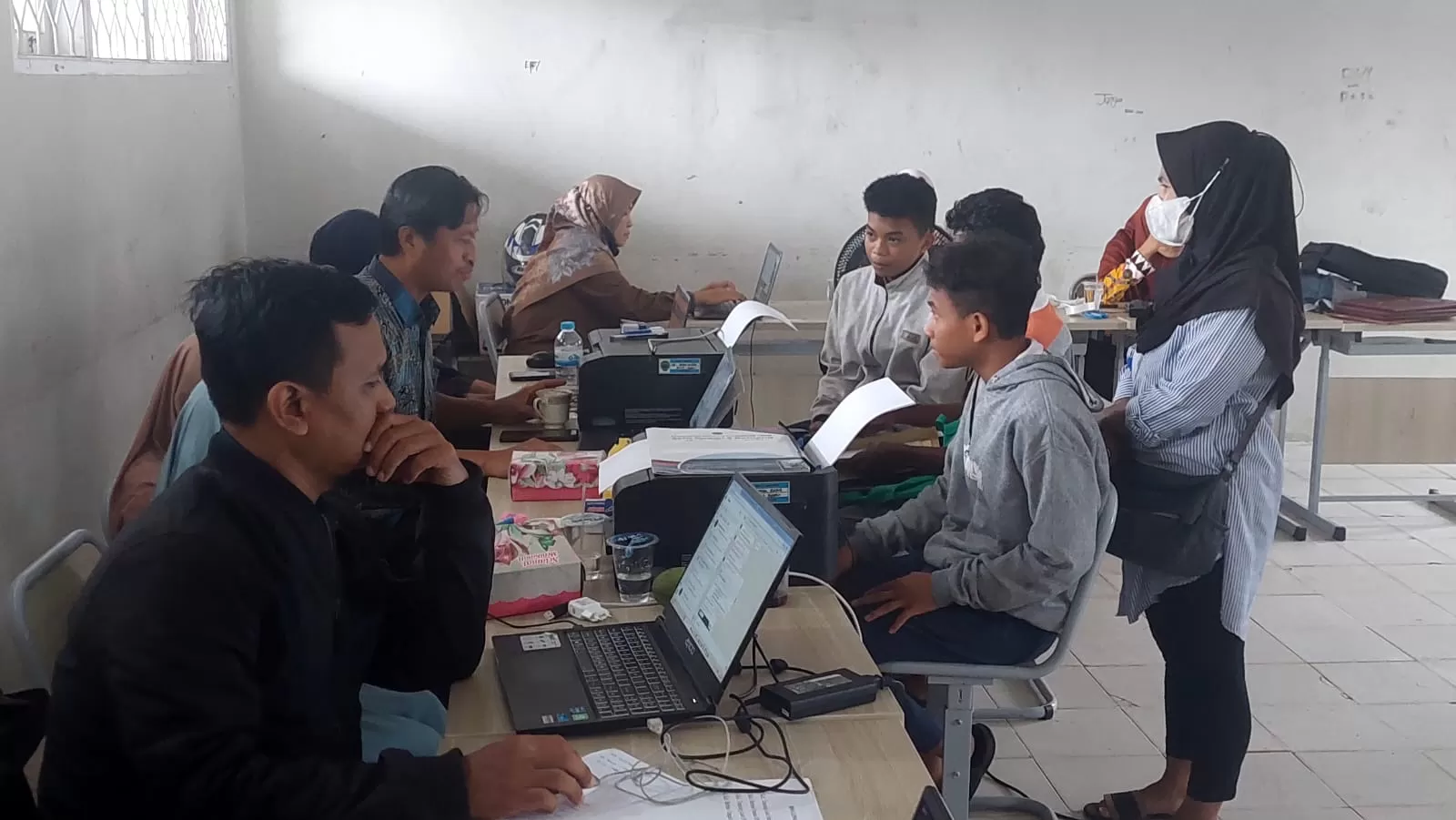 VERIFIKASI: Pendaftar datang ke sekolah untuk melakukan verifikasi berkas bersama operator sekolah.  