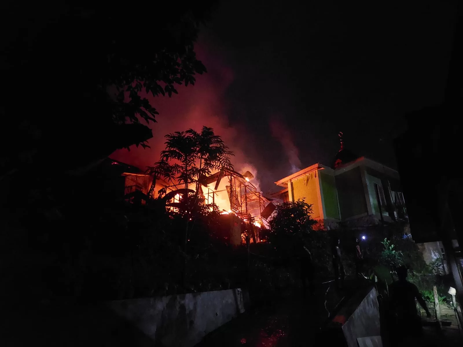 Kondisi rumah terbakar di Jalan Margatama Kelurahan Bukit Biru, Tenggarong yang sedang dipadamkan personil damkar (Elmo/Prokal.co)  