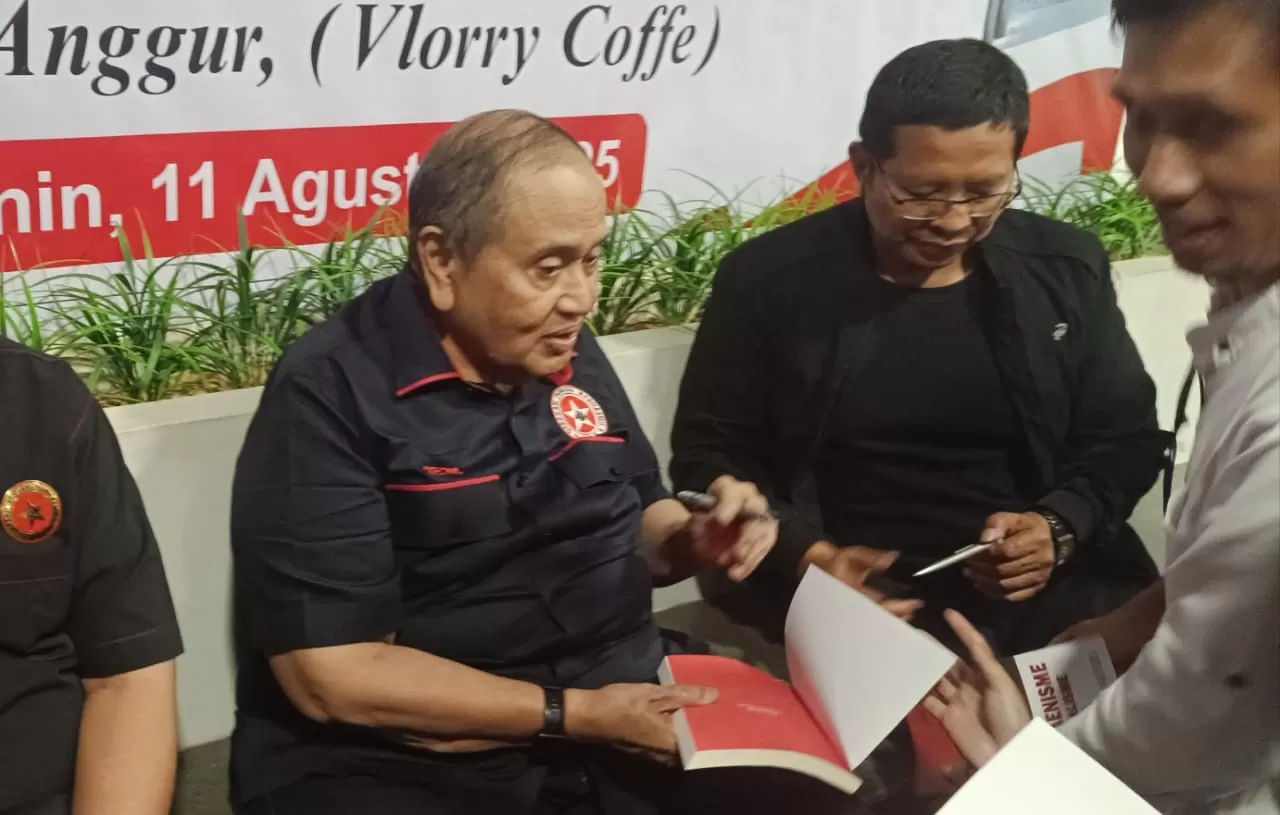 Emir menandatangani buku.