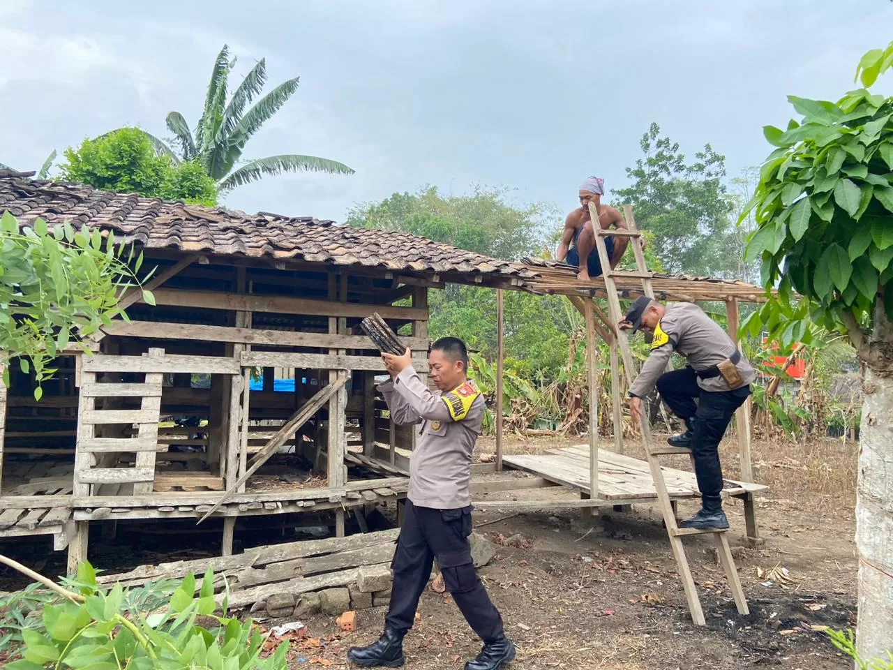 Gotong royong dalam membantu membersihkan rumah warga yang mengalami kerusakan akibat bencana. (Humas Polres Tulang Bawang Barat)
