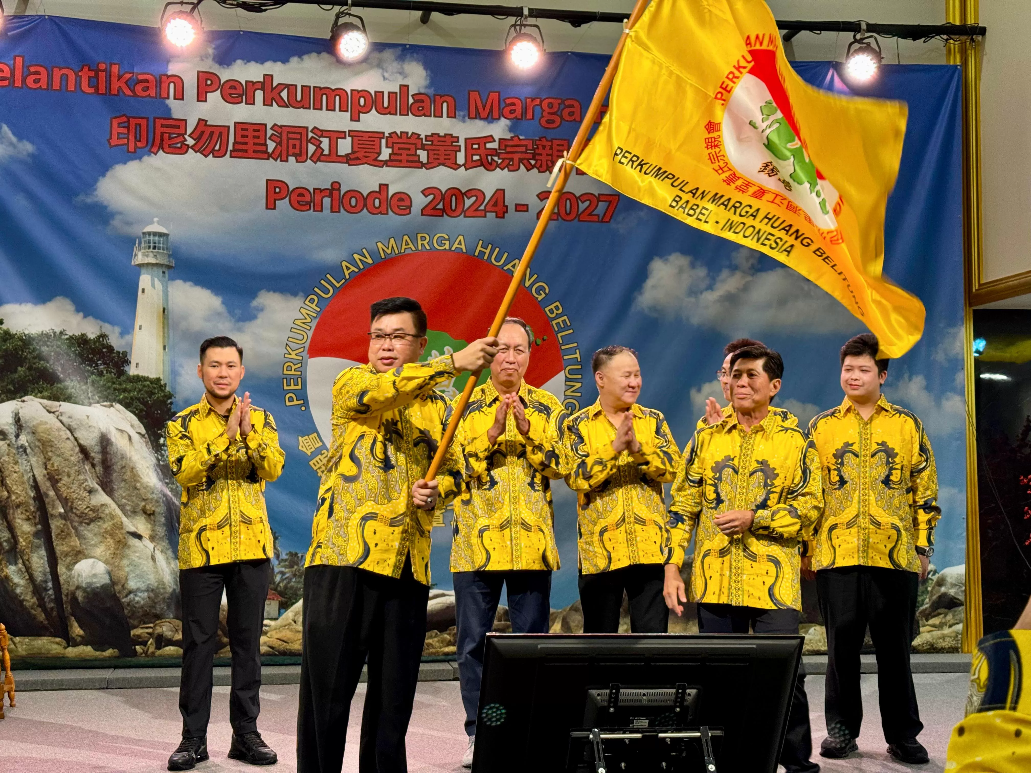 Ketua terpilih Wongso Indrajit mengibarkan pataka Marga Huang Belitung disaksikan oleh Ketua Umum Edi Yansah. (foto: istimewa)
