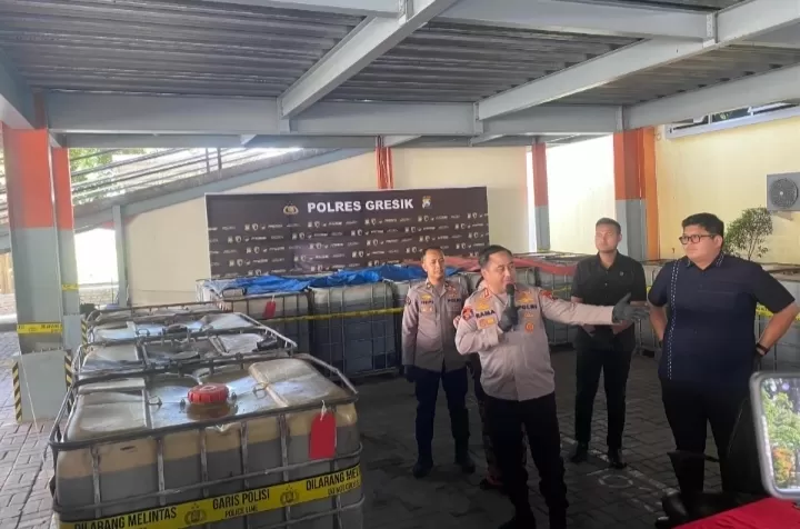 Polisi saat memamerkan BB bbm subsidi jenis solar yang ditimbun di Gresik (Hilmi/klikmedianetwork.com)