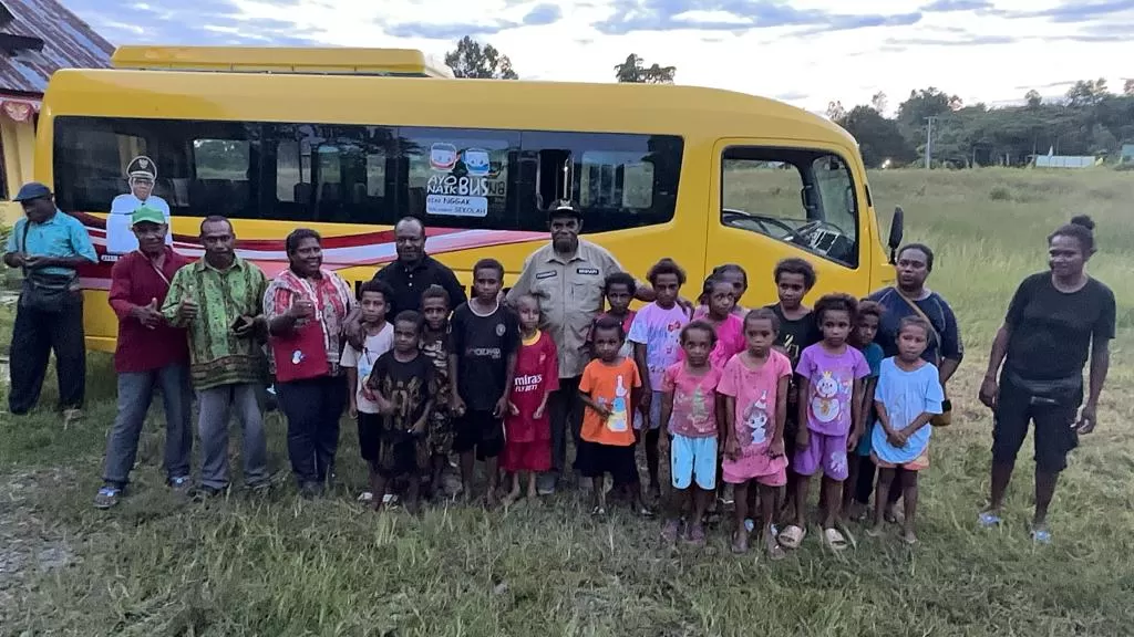 Bupati Keerom, Piter Gusbager, S.Hut., MUP, foto bersama dengan sejumlah anak-anak usai menyerahkan bantuan bus sekolah di Distrik Senggi, Kamis (25/1) lalu. (Istimewa)