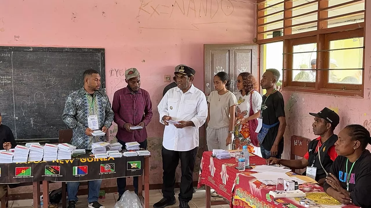 Bupati Keerom, Piter Gusbager, S.Hut., MUP., didampingi keluarga saat melakukan pencoblosan di Kampung Workwana, Rabu (14/2) lalu.   (Mustakim Ali/Ceposonline.com)