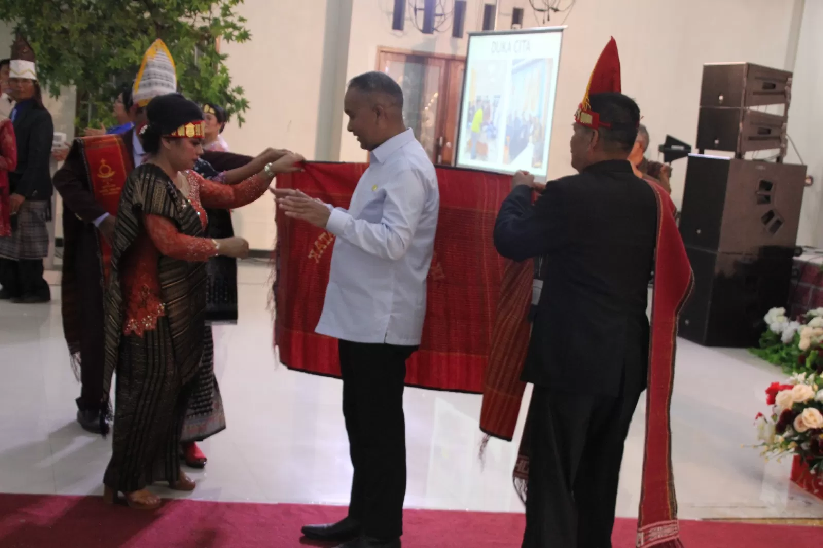 Penjabat Gubernur Papua Pegunungan Dr. Velix Vernando Wanggai, S.IP, MPA saat dipakaikan kain ulos oleh IKB Jayawijaya sebagai salah satu cara penghormatan.  (Ceposonline.com/DENNY)