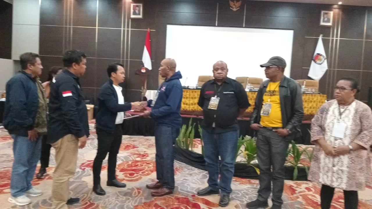 Komisioner KPU Provinsi Papua, Amijaya Halim ketika menyerahkan berita acara hasil pleno kepada para saksi (Foto: HANS PALEN/Ceposonline.com)