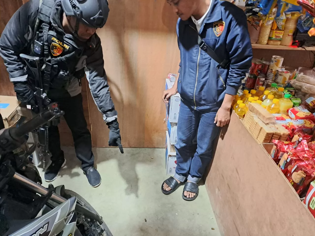 Anggota Polres Lanny Jaya saat Mendatangi kios milik Brigpol Johan Herik Sibarani seusai penembakan terjadi, Selasa (10/09/2024). (Foto Humas Polda)