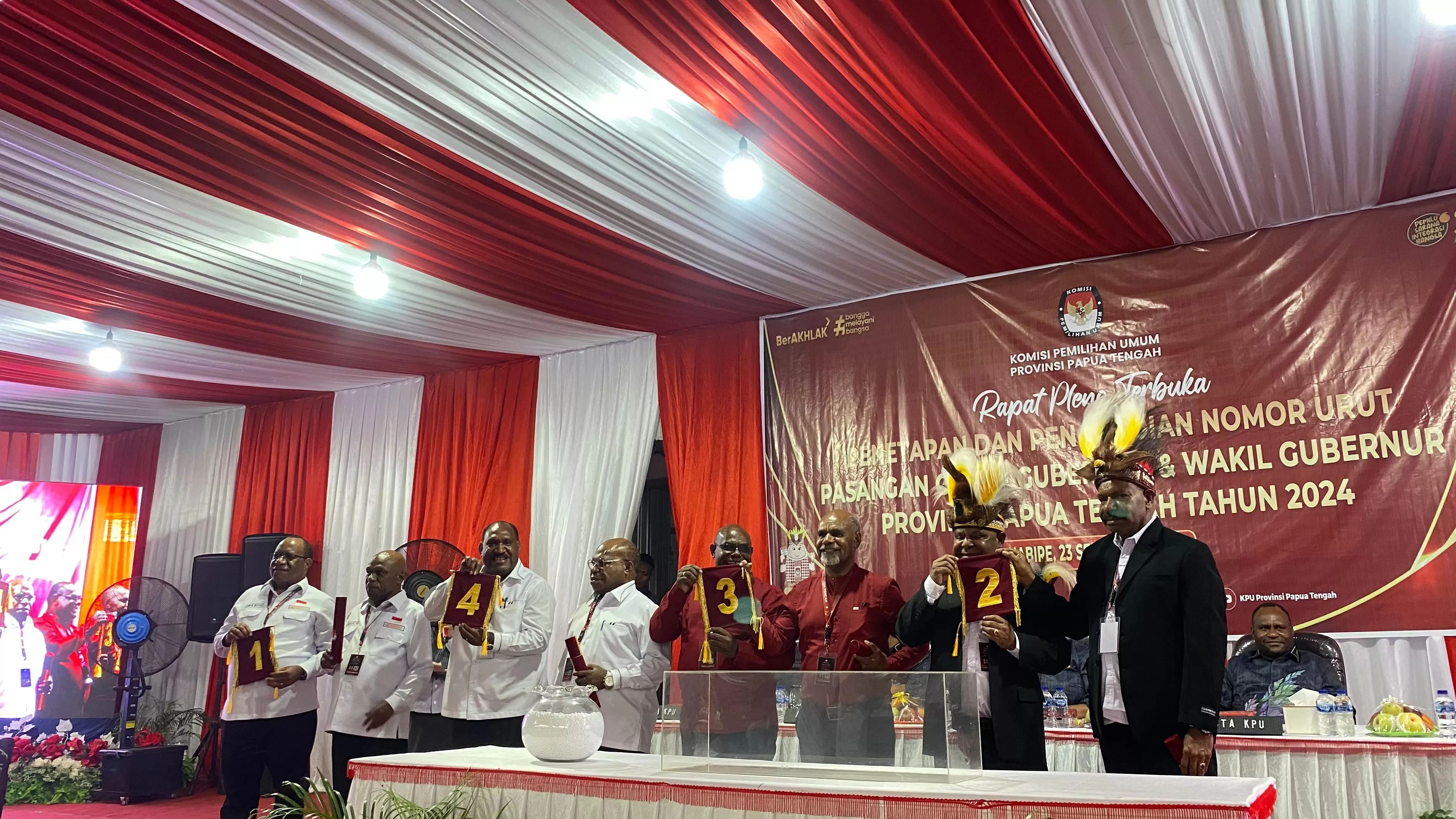 Paslon saat menunjukkan nomor urut kepada tim pengusung dan masyarakat yang hadir menyaksikan rapat pleno terbuka pengundian dan penetapan nomor urut Cagub Cawagub Papua Tengah, Senin (23/9/3024).  ((Cenderawasi Pos/Theresia Tekege))