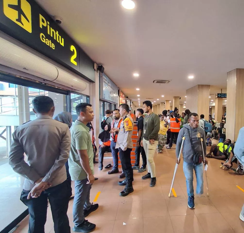 Kapolsek (KP3), Bandara Sentani, Iptu Wajedi saat bersama penumpang pesawat Trigana Air saat dievakuasi di Bandara Sentani, Selasa (5/11/2024).(Humas Polres Jayapura For CEPOS.ONLINE.COM)  