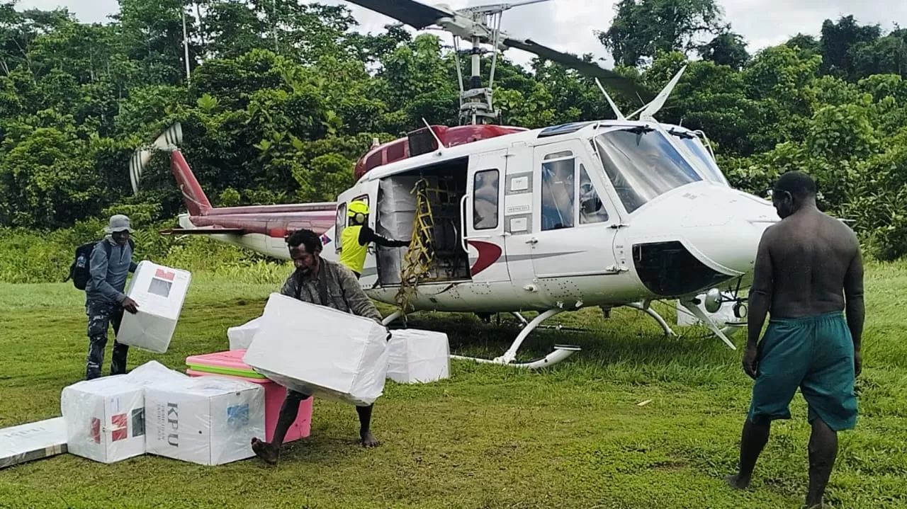 Masyarakat menurunkan logistik di salah satu distrik yang pendistribusian logistiknya menggunakan helikopter. (KPU Dogiyai for Cepos).