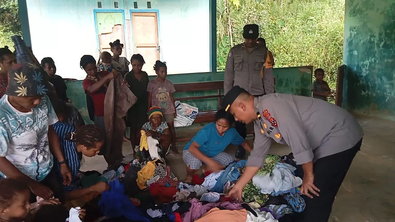 Tampak Bhabinkamtibmas Polsek Web Polres Keerom, Aipda Nataniel Nari dan Kanit Bhabinkamtibmas Sat Binmas Ipda Leo Andreas Purba saat membagikan pakaian layak pakai kepada masyarakat di Kampung Yambra