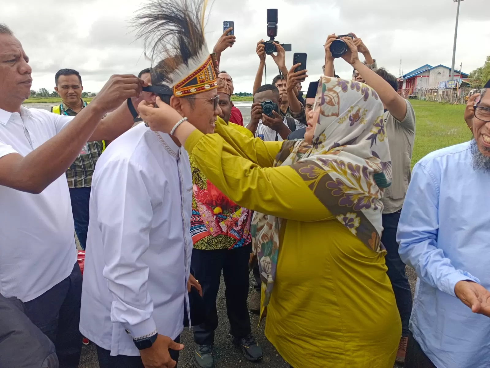 Wakil Bupati Merauke Fauzan Nihayah saat menyambut Ketua MUI Pusat Muhammad Cholil Nafis dengan memasang mahkota di kepala di Bandara Mopah Merauke, Jumat (9/5) (Ceposonline.com/Sulo)