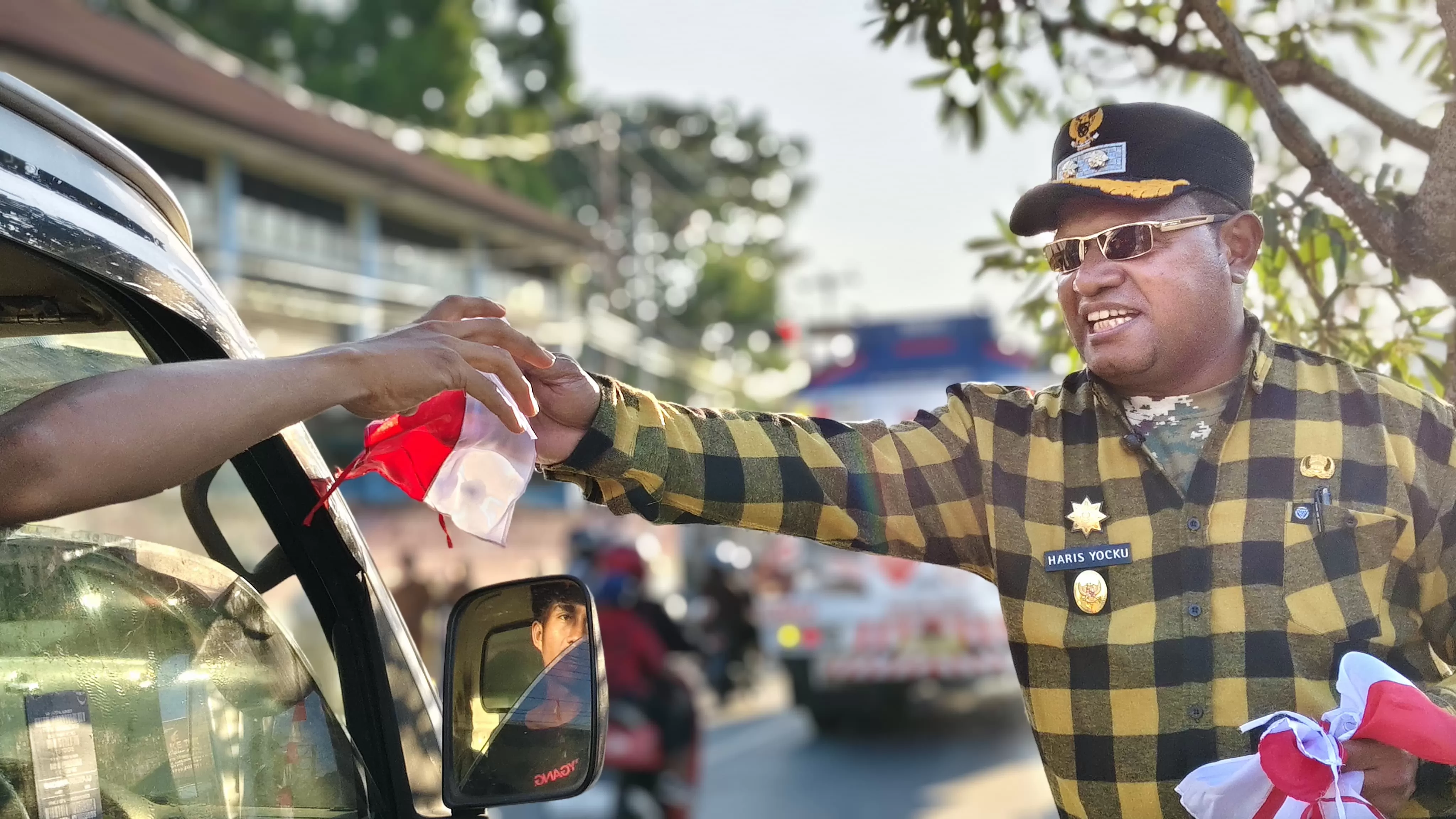 Wakil Bupati Jayapura Harris Richard Yocku bersama jurnalis Kabupaten Jayapura membagikan gratis atribut bendera merah putih bagi pengendara roda dua dan roda empat di pertigaan jalan bandara Sentani