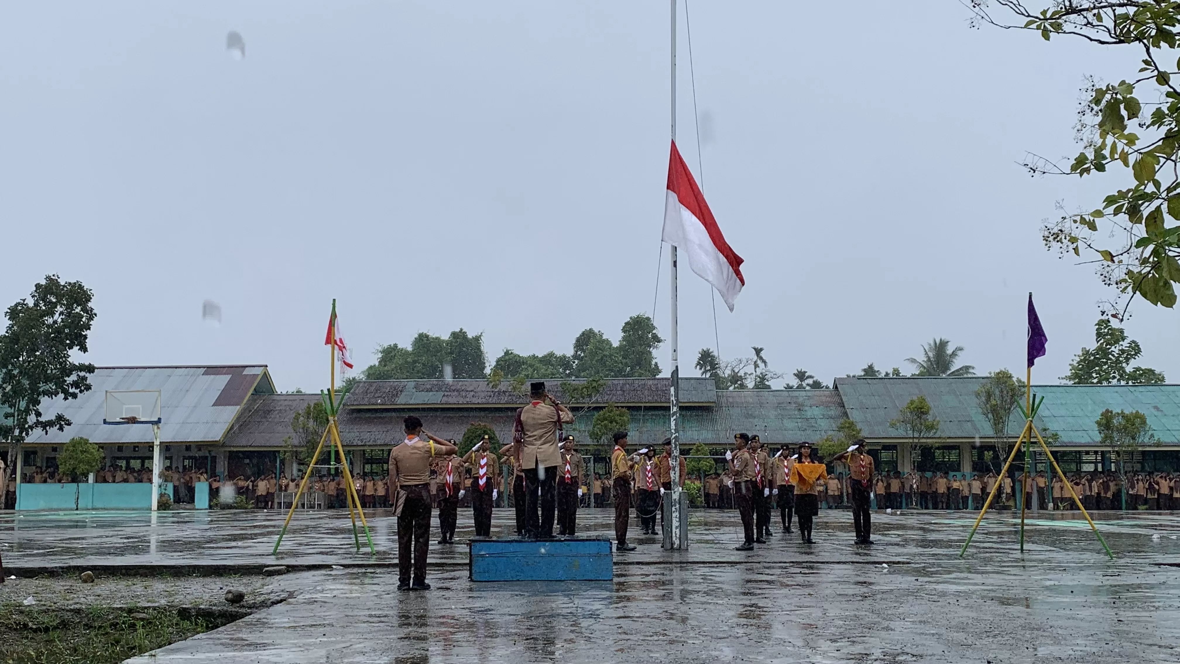Momen pengibaran bendera pusaka dalam upacara peringatan HUT Pramuka ke-64 tahun di SMA Negeri 1 Mimika di bawa derasnya hujan, bertempat di lapangan sekolah, Kamis (14/8/2025). (Cenderawasih Pos/Moh. Wahyu Welerubun)