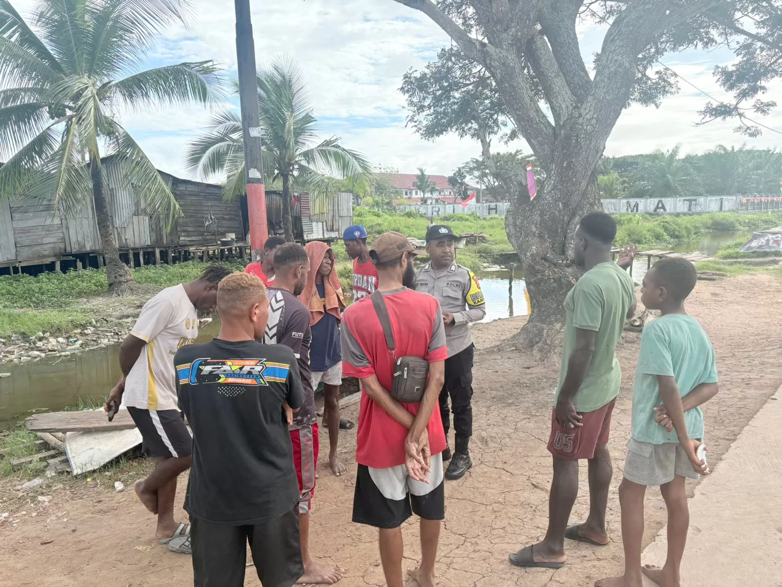 Bhabinkamtibmas Polres Merauke, Bripka Feri Yarona saat menyelesaikan kesalahpahaman antarkelompok warga yang nyaris berujung adu fisik, di Kelurahan Karang Indah Merauke, Kamis (14/8/2025).