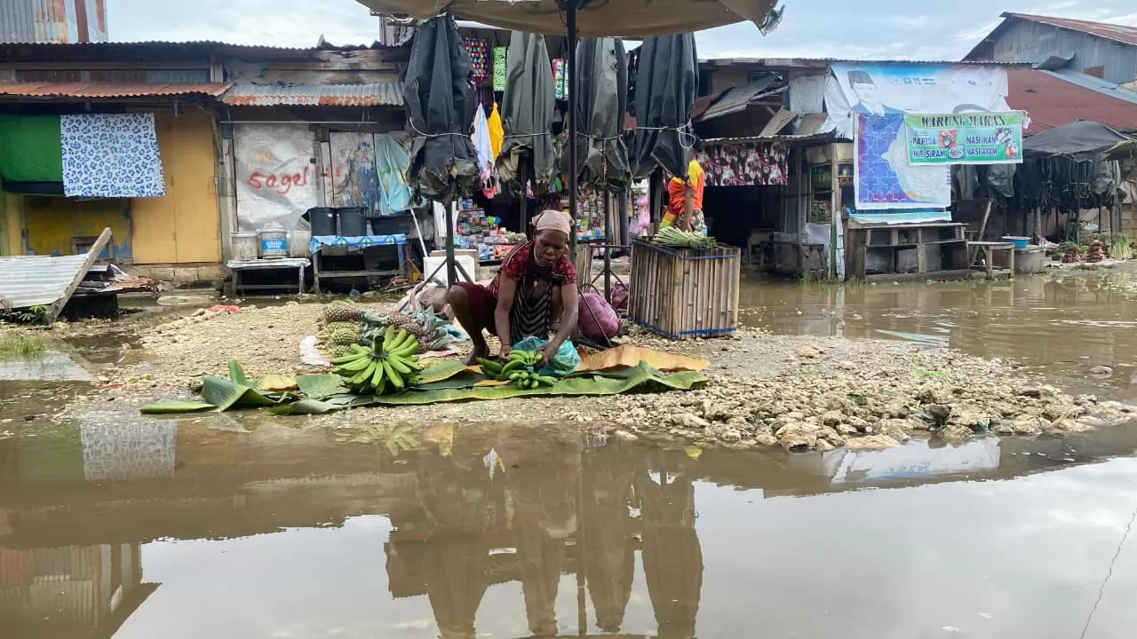 Tampak salah seorang Mama-mama Papua sementara menyiapkan jualan di tempat yang tergenang air, di pasar Youtefa, Kamis (11/12/2025).(Ceposonline.com/Jimi).
