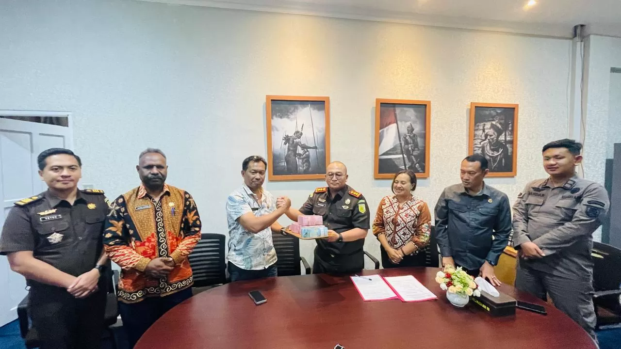 Kejari Jayawijaya Sunandar saat menyerahkan hasil penghitungan kerugian negara sebesar Rp315 juta kepada Kepala BPKAD Kabupaten Jayawijaya di Kantor Kejari Jayawijaya, Kamis (11/12/2025).