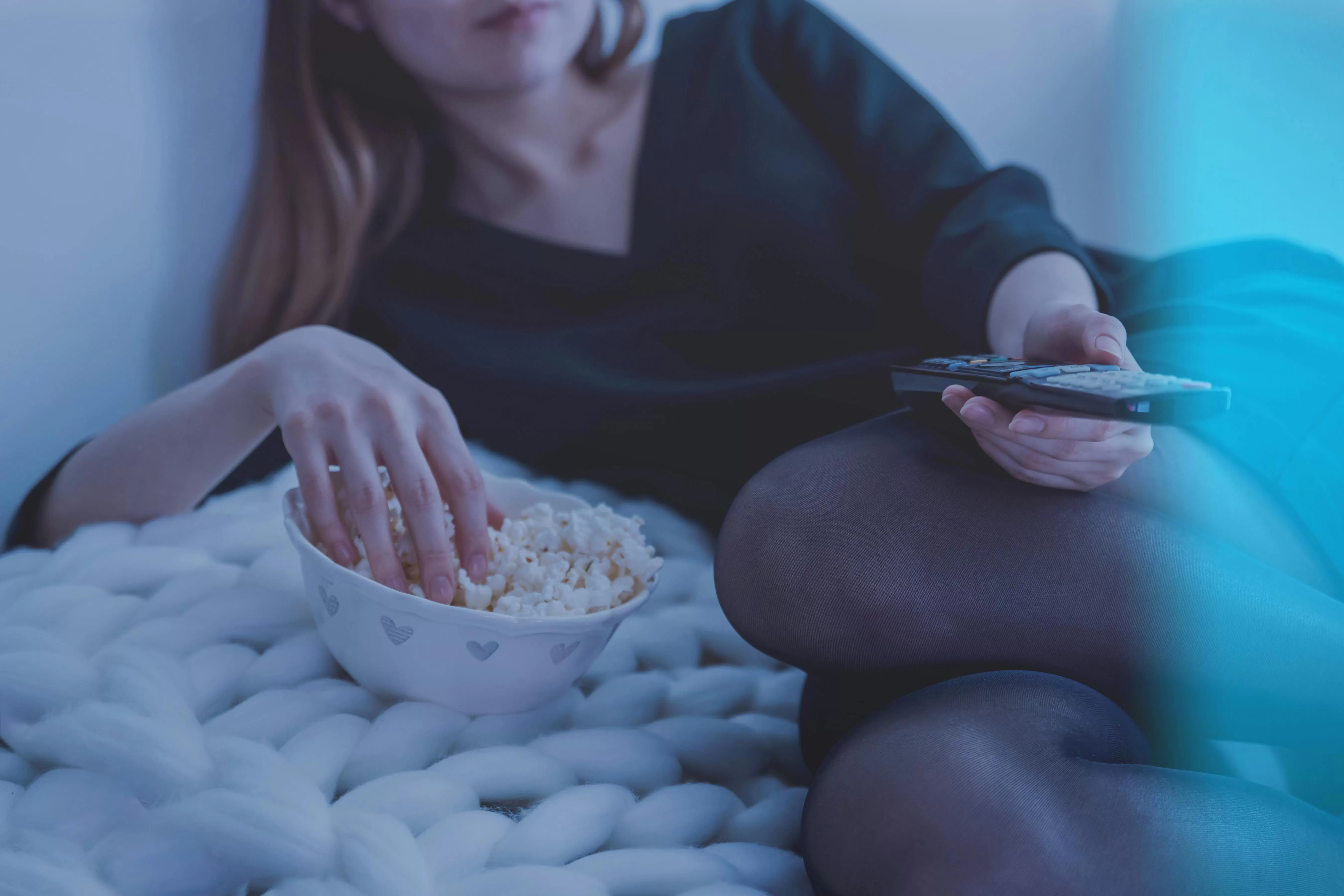 Perempuan bersantai menikmati popcorn sambil menonton Foto oleh JESHOOTS.com