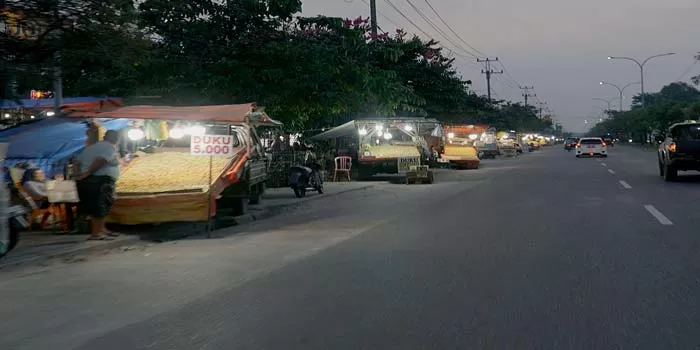 Pedagang kaki lima (PKL) dan pedagang buah duku menggunakan mobil kembali berjualan di trotoar dan bahu Jalan HR Soebrantas, Kecamatan Tuah Madani, Selasa (19/3/2024). Keberadaan PKL tersebut te (DEFIZAL/Riaupos.co )