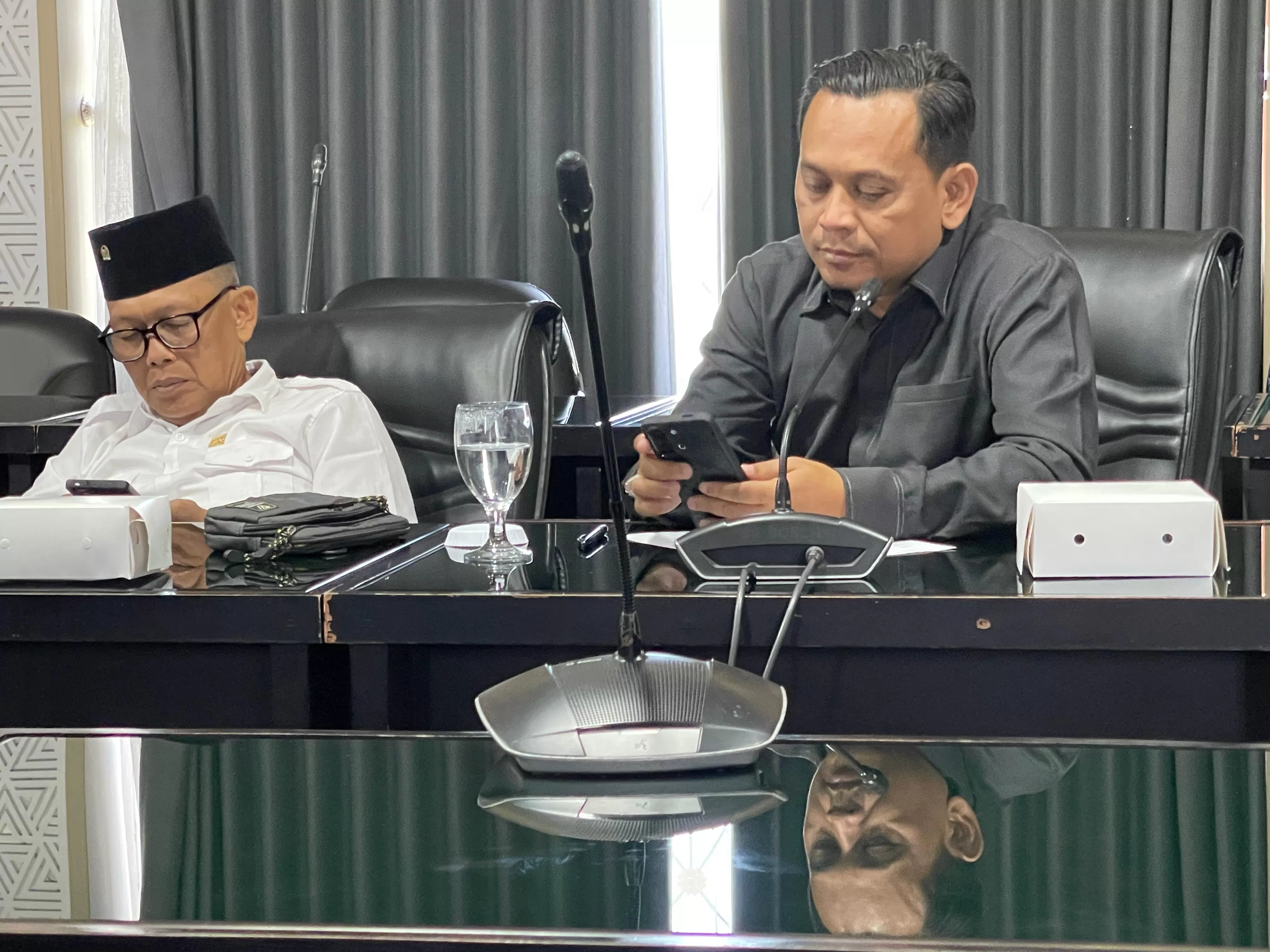 Herman tengah memeriksa laporan di gawainya.  (Jaka)