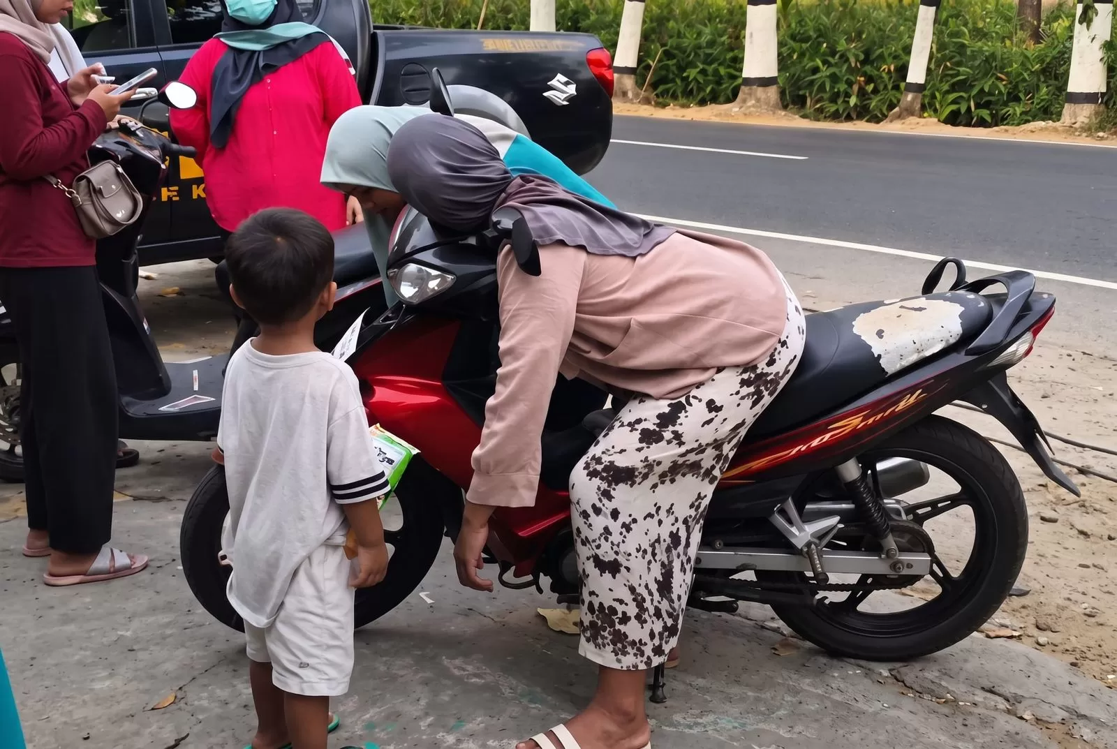 Petugas kepolisian berada di lokasi saat Lu'luatun Nikmah ditemukan meninggal di atas sepeda motor, sementara anaknya berada di dekat motor. (Tangkapan layar Instagram)
