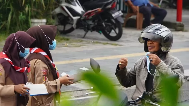 Gerakan Pramuka Kwarcab 12 Kota Padang Panjang membagikan masker kepada masyarakat yang beraktivitas di luar di tengah penurunan kualitas udara akibat kabut asap. (Foto: Kominfo Padang Panjang)