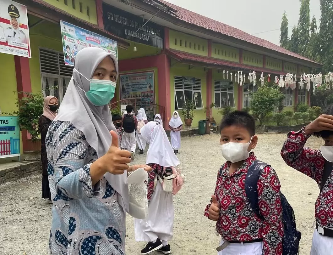 Pembagian masker kepada siswa dilakukan Puskesmas di Kabupaten Dharmasraya untuk melindungi kesehatan di tengah kabut asap karhutla. (Foto: Kominfo Dharmasraya)