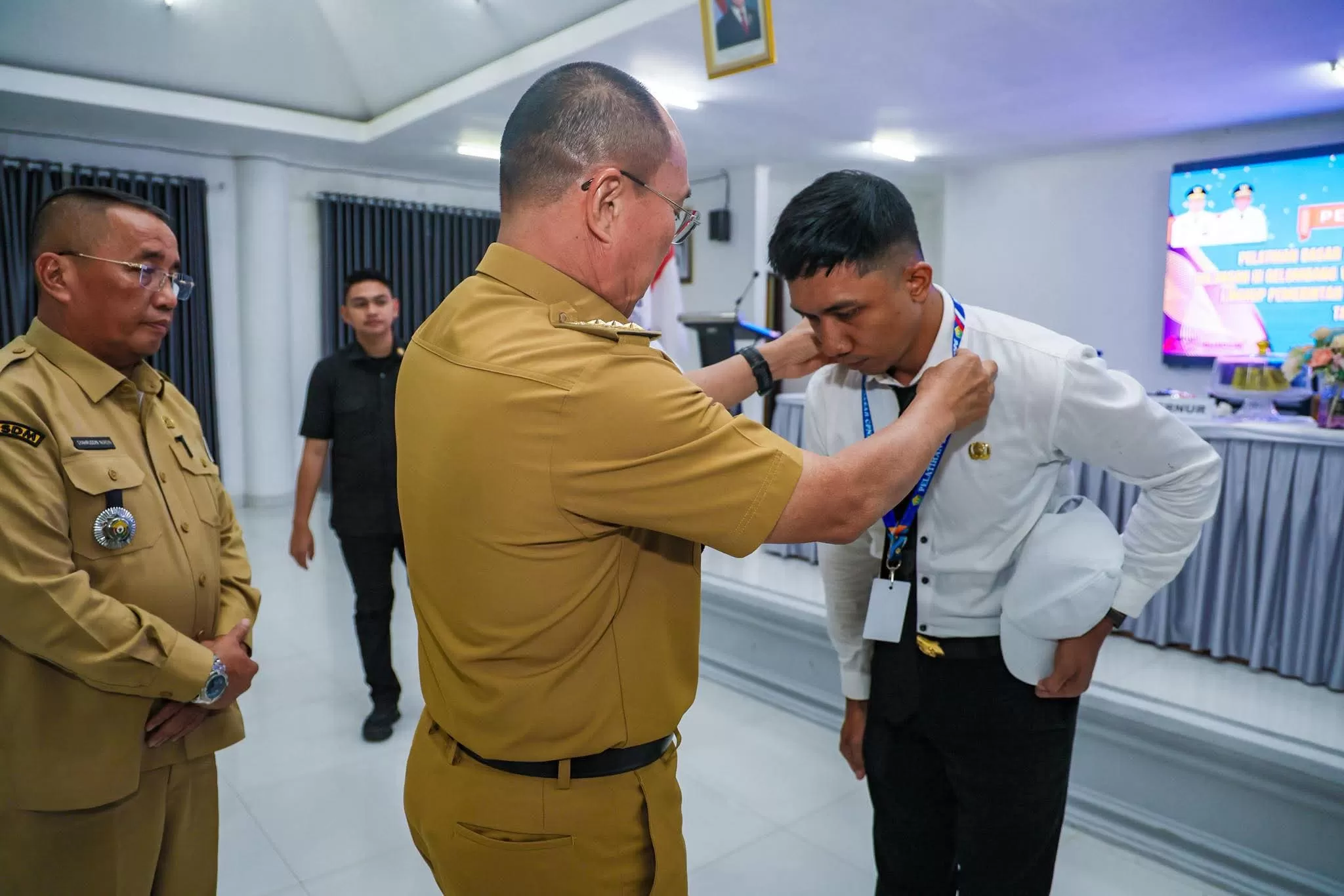 Gubernur Sultra saat menyematkan id card kepada peserta diksar CPNS 2026