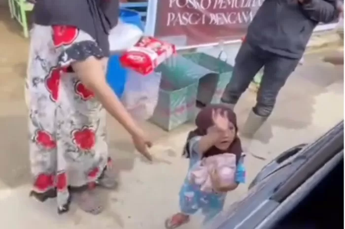 Tangkapan layar seorang bocah yang dengan gembira menerima bantuan makanan dan pakaian di tengah suasana pengungsian banjir Aceh Tamiang (Foto: GENMUSLIM.id/dok: TikTok @zaits_bf)
