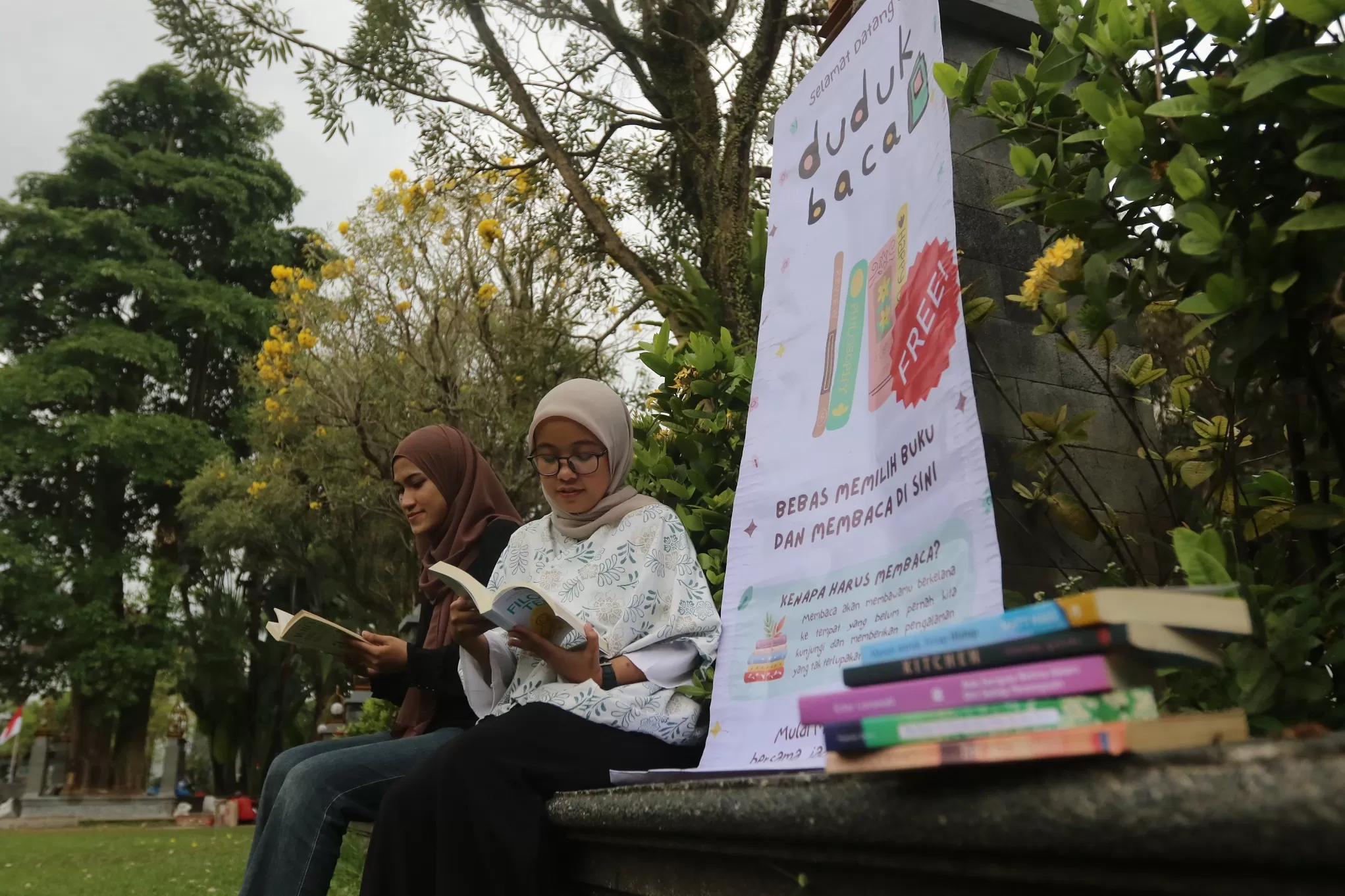 TAMBAH WAWASAN: Dua mahasiswa Universitas Brawijaya (UB) membaca buku di taman kampus. ((Darmono/Radar Malang))