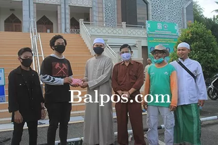Mahasiswa menyerahkan dana bantuan untuk perbaikan pagar masjid.