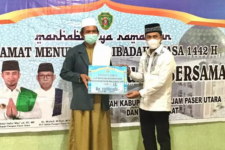 SAFARI RAMADAN: Bupati Abdul Gafur Mas’ud (kanan) menyerahkan bantuan sebesar Rp 25 juta untuk Masjid Darul Aman. AGM meminta warga PPU untuk tetap menerapkan protokol kesehatan.