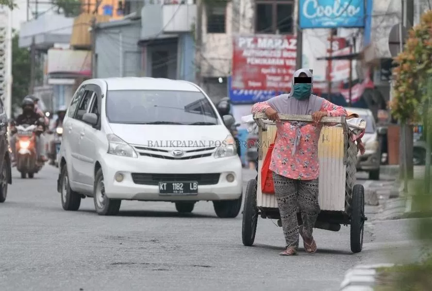 TAMBAH BANYAK:Pemulung menggunakan gerobak di jalan-jalan protokol di Balikpapan semakin marak. Mereka memulung sambil membawa anak kecil dan menyusuri daerah-daerah tak ada bak sampah.