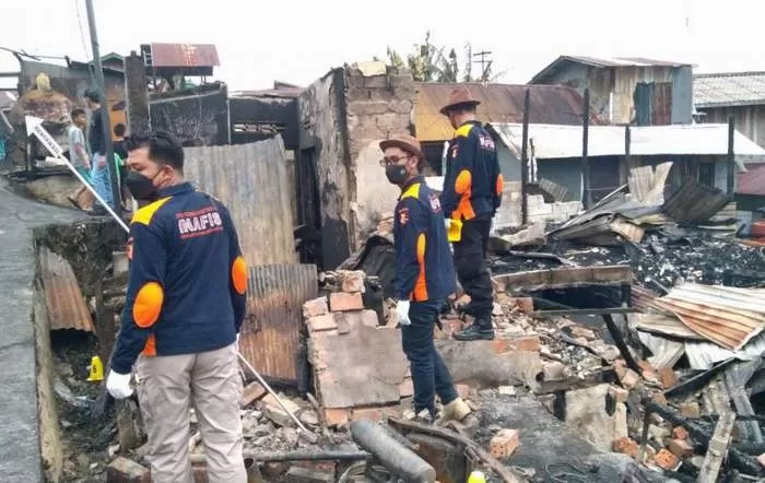 Polisi memeriksa puing kebakaran di Gunung Bugis.