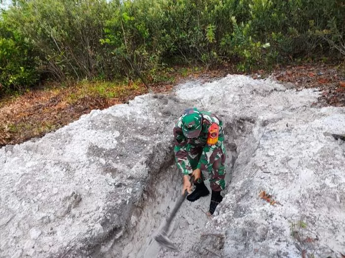 KERJA IKHLAS: Serka Cahyo Budianto turun tangan menggali kubur dikarenakan kesulitan mencari orang yang mau membantu menggali kubur jenazah Covid-19. IST.