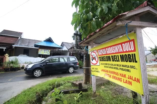 Spanduk imbauan punya garasi yang terpasang di salah satu perumahan warga di Balikpapan.