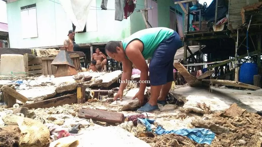 BERSIHKAN PUING: Warga bergotong royong membersihkan puing rumah yang rusak diterjang badai dan ombak besar di RT 25 Kelurahan Damai, Balikpapan Selatan