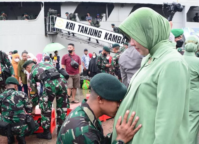 Seorang prajurit TNI mencium perut istrinya yang hamil, sebelum berangkat ke Papua.